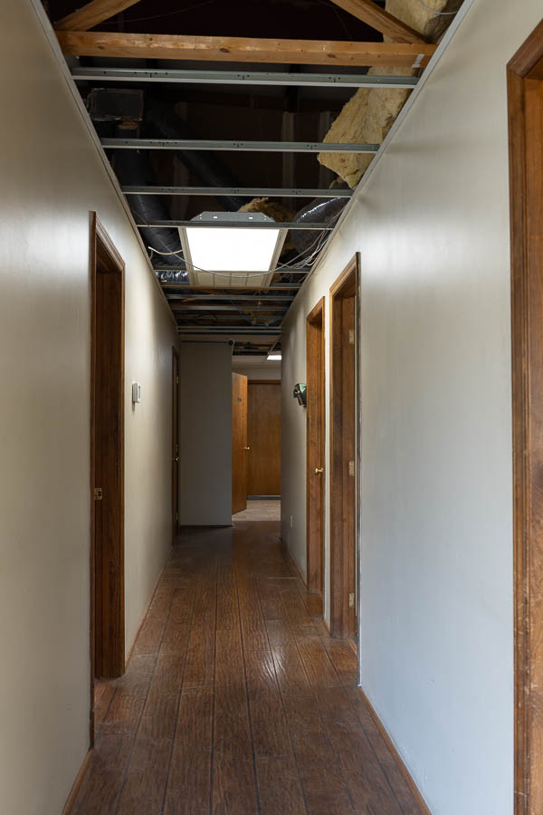 Early shots of a hallway remodel with exposed ceiling