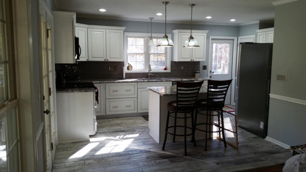 Kitchen remodel after shot featuring island and hanging lights