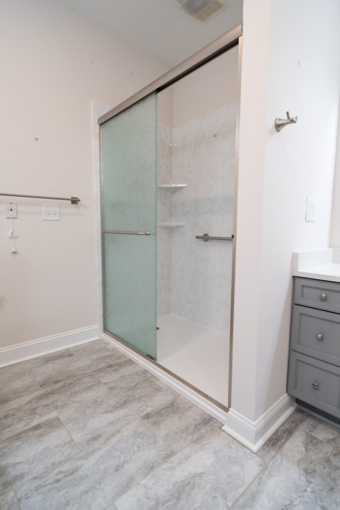 New bathroom shower with sliding doors and hand rail